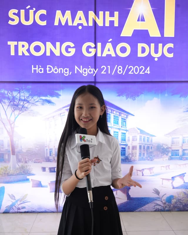 Học viên KIDS+ cầm micro giới thiệu trước máy quay tại hội thảo